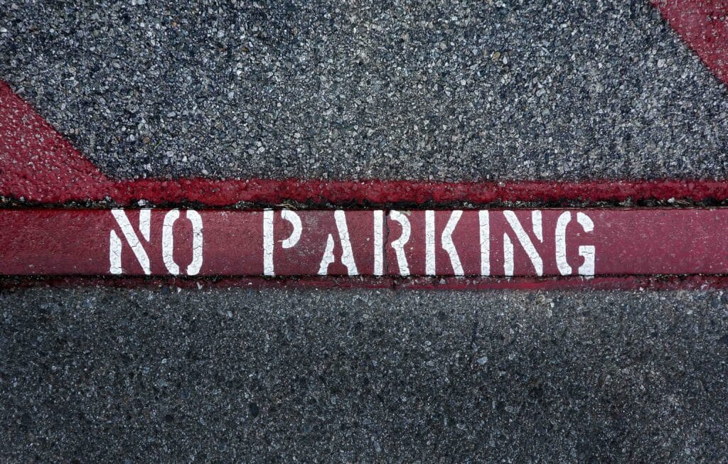 Street “No Parking” marking demonstrating clear line marking on a coated paved surface.