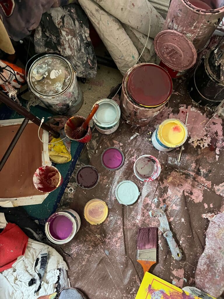 Messy workspace with leftover paint and tools awaiting safe storage, reuse or Paintback drop-off.